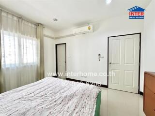 Bright bedroom with bed, air conditioner, and white interiors