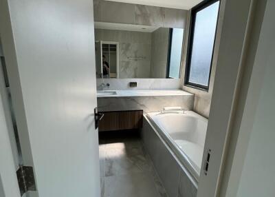 View of a modern bathroom with bathtub and sink