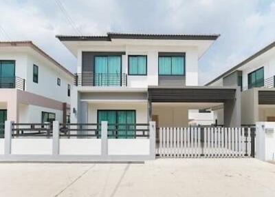 Modern two-story house with balcony and gated fence