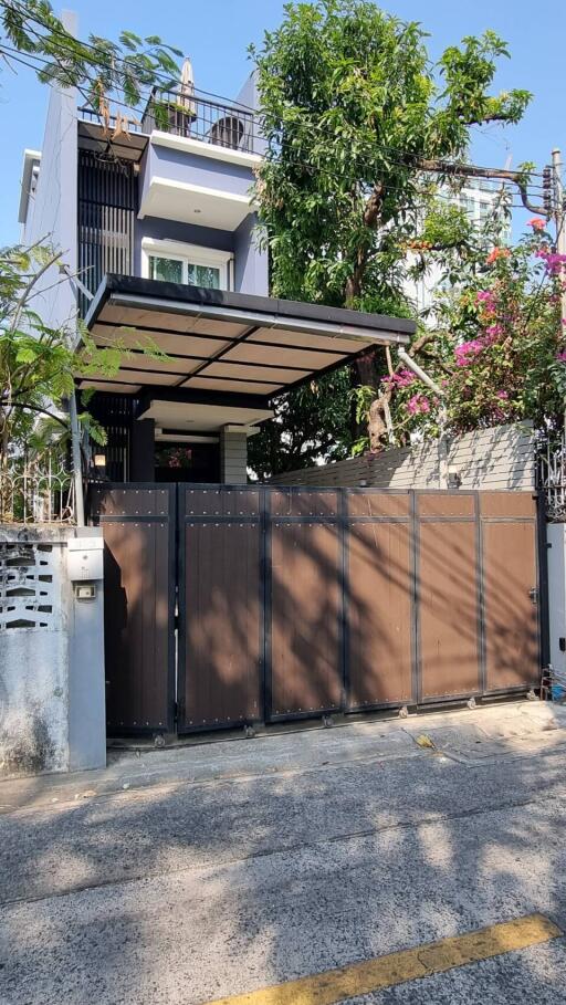 Modern house exterior with a gated entrance and balcony