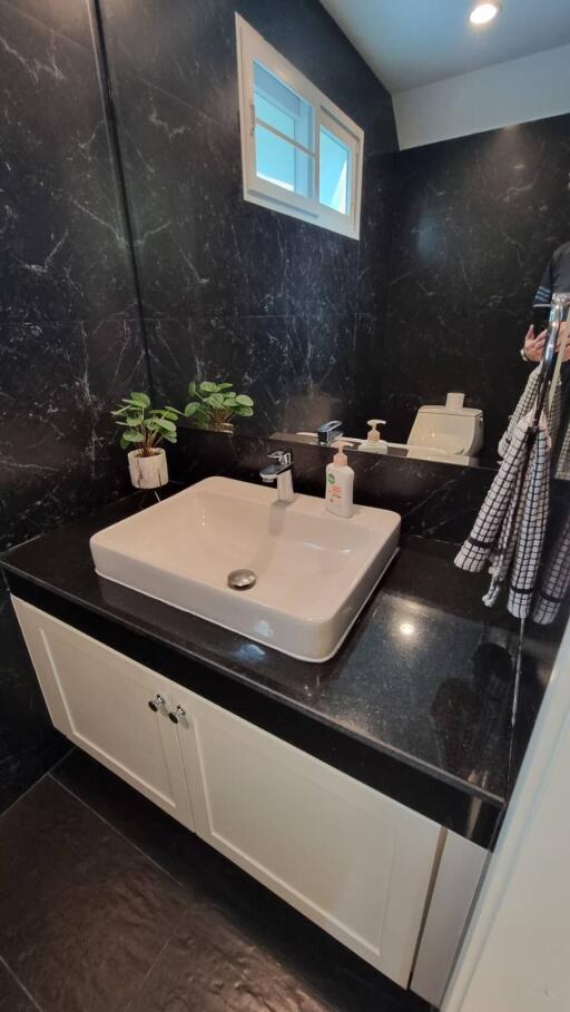 modern bathroom with black marble walls and white sink