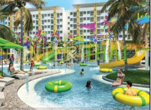 Colorful outdoor recreational pool area with people swimming and colorful water features