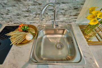 Modern kitchen sink with stylish backsplash and decorative items