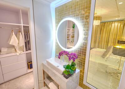 Modern bedroom with illuminated vanity and closet