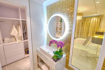 Modern bedroom with illuminated vanity and closet