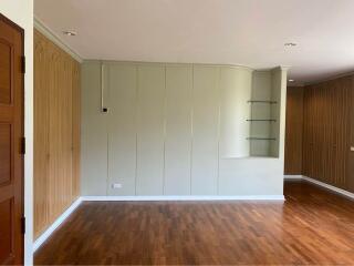 Living room with wooden flooring and built-in shelves