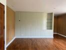 Living room with wooden flooring and built-in shelves