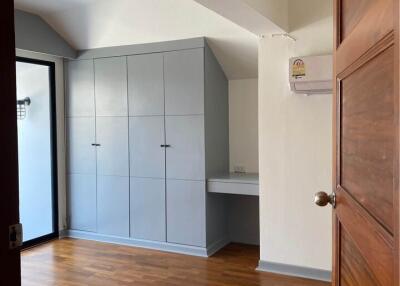 Bedroom with wooden flooring, built-in storage, and air conditioning