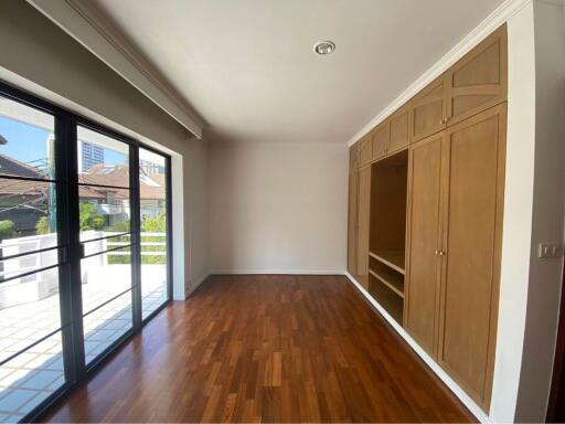 Bright and spacious bedroom with wooden flooring and built-in closets