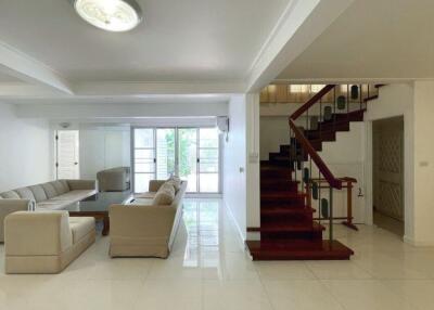 Spacious living room with modern furniture and staircase