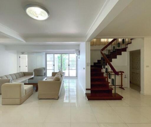 Spacious living room with modern furniture and staircase