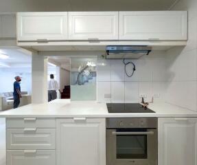 Modern kitchen with white cabinetry and built-in appliances