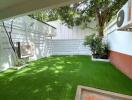 Backyard garden with artificial grass and plants