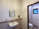 Modern bathroom with sink, mirror, and toilet