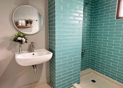 Modern bathroom with teal tiles and a walk-in shower