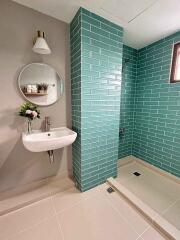 Modern bathroom with teal tiles and a walk-in shower