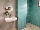 Modern bathroom with teal tiles and a walk-in shower