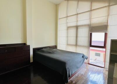 Bedroom with a bed, chest of drawers, and large window