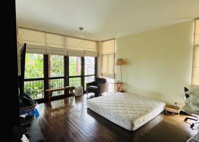 Bedroom with large windows and wooden floors