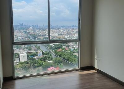 Empty bedroom with large window and city view