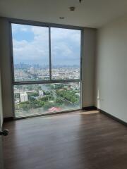 Empty bedroom with large window and city view