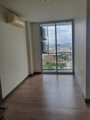 Empty living area with a view of the city from the balcony