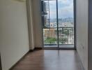 Empty living area with a view of the city from the balcony