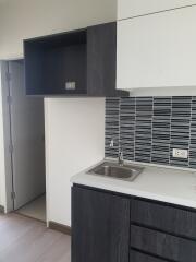 Modern kitchen with tiled backsplash and dark cabinets