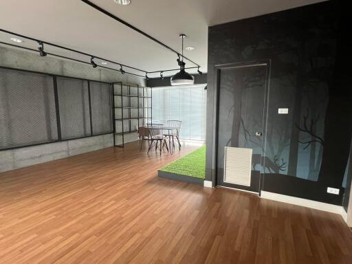 Modern living area with wooden flooring and large windows