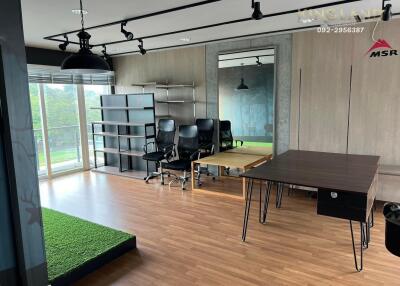 Modern office space with large windows and green outdoor view