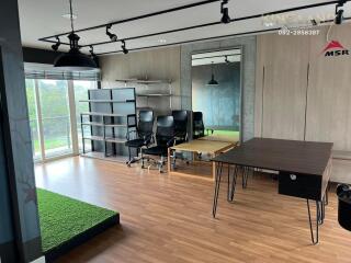 Modern office space with large windows and green outdoor view