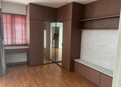 Bedroom with wooden floor, built-in wardrobe and shelves