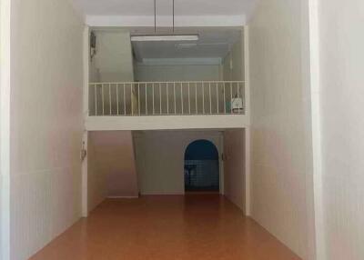 Spacious living area with a mezzanine and ceiling fan.