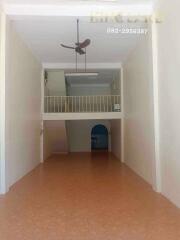 Spacious living area with a mezzanine and ceiling fan.