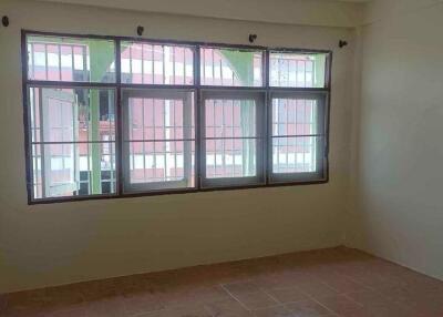 Empty bedroom with tiled floor and large window