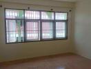 Empty bedroom with tiled floor and large window