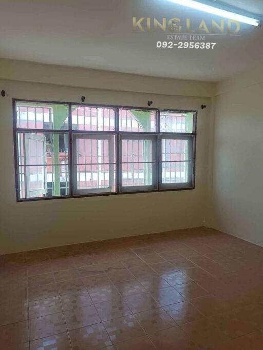 Empty bedroom with tiled floor and large window