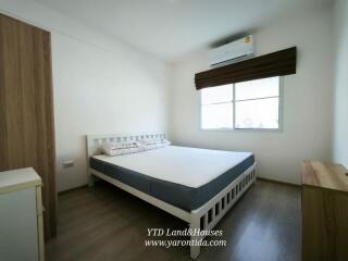 Modern bedroom with a large bed, window, and air conditioning