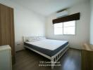 Modern bedroom with a large bed, window, and air conditioning