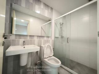 Modern bathroom with sink, toilet, and glass-enclosed shower