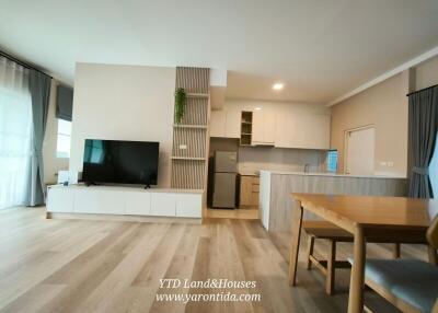 Spacious modern living and kitchen area with hardwood floors and natural light