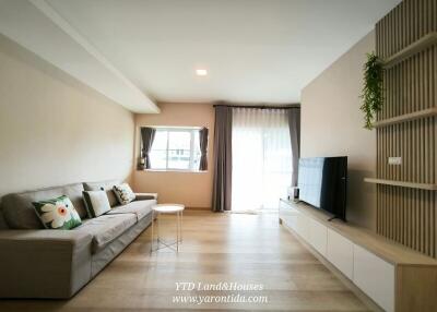 Spacious and well-lit living room with a cozy sofa and modern entertainment unit