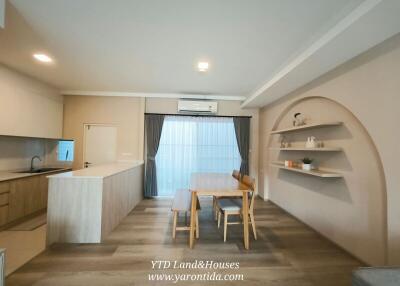 Contemporary dining area with wooden table and chairs, built-in shelves