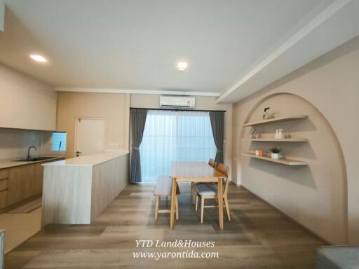 Contemporary dining area with wooden table and chairs, built-in shelves