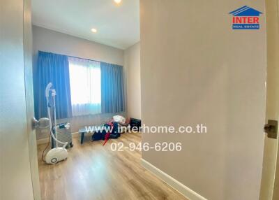 Bedroom with wooden floor, window, and exercise equipment