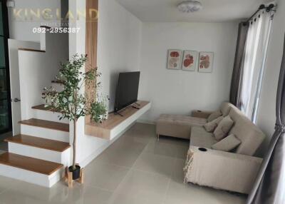 modern living room with a TV, sofa, and plant