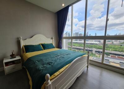 Spacious bedroom with large window offering a city view