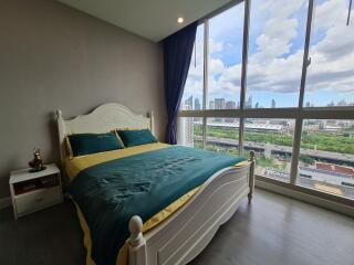 Spacious bedroom with large window offering a city view