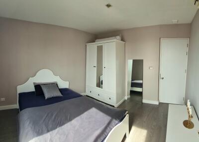 Spacious bedroom with double bed, wardrobe, and a large window