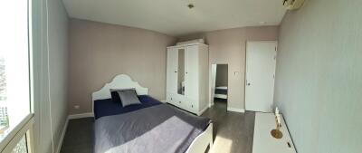 Spacious bedroom with double bed, wardrobe, and a large window